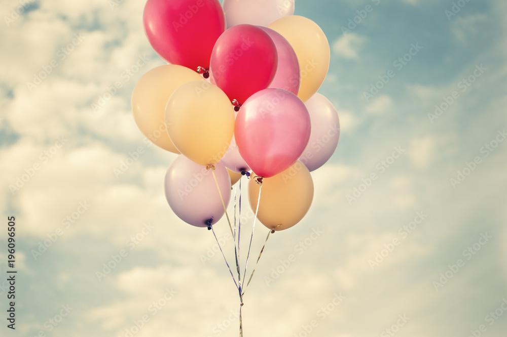 Big bunch of pastel colour balloons floating with calm sky toned vintage