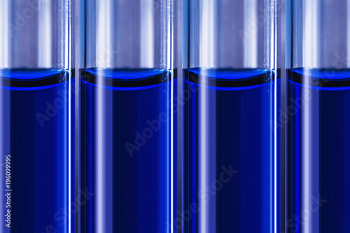 Blue liquid in tubes on blured medical background photo