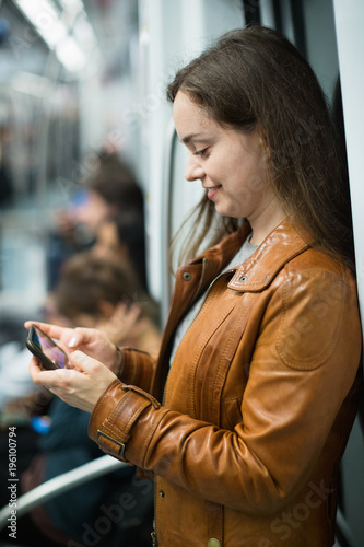 Young smiling woman reading from mobile phone screen