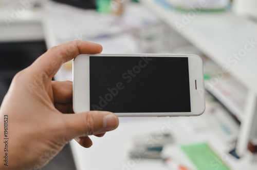 Businessman use mobile phone on light background for photo or video. Writing text, checking calls, reading messages. Close up picture of communication technology device