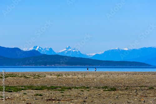 Rathtrevor Beach with view of Snowcapped Mountain Ranges at low tide in Parksville, British Columbia, Canada photo