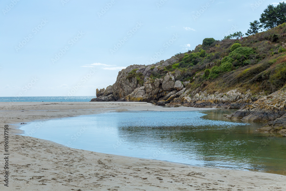 European forest cliff and rocks on a estuary sea inlet with clear water and white sand