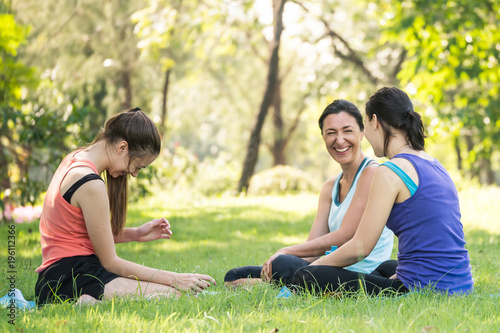 Activities in the family, mother and daughter relaxing in the park after practicing yoga.