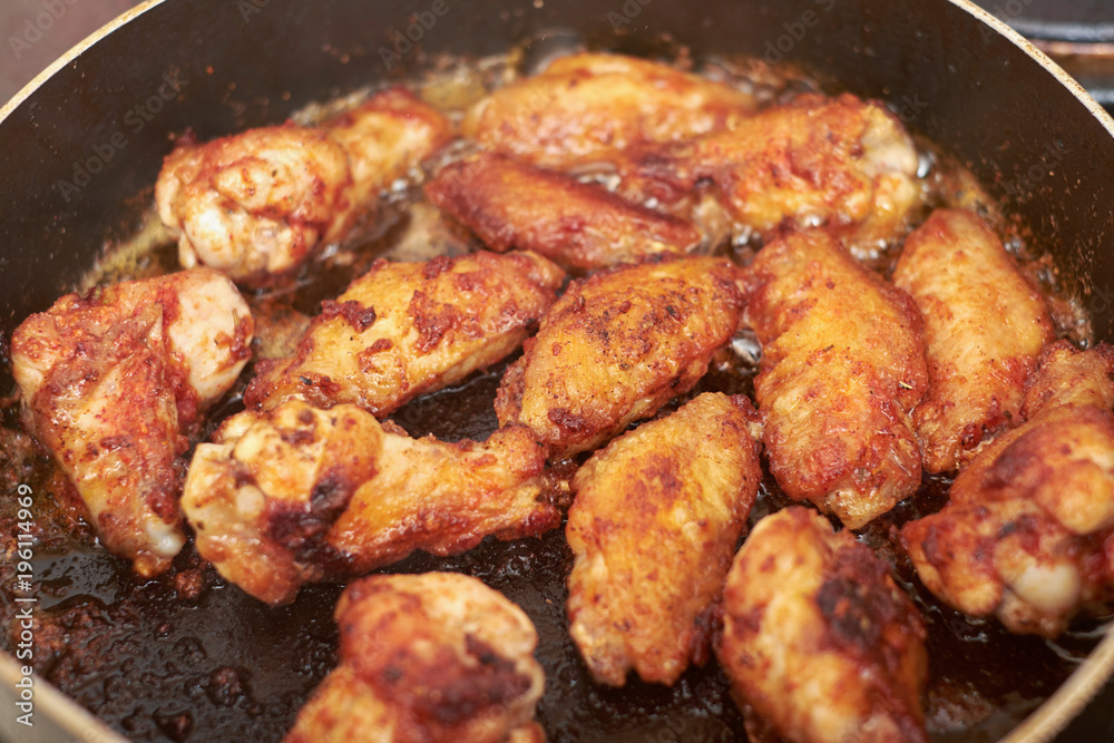 chicken wings frying with oil on a hot pan
