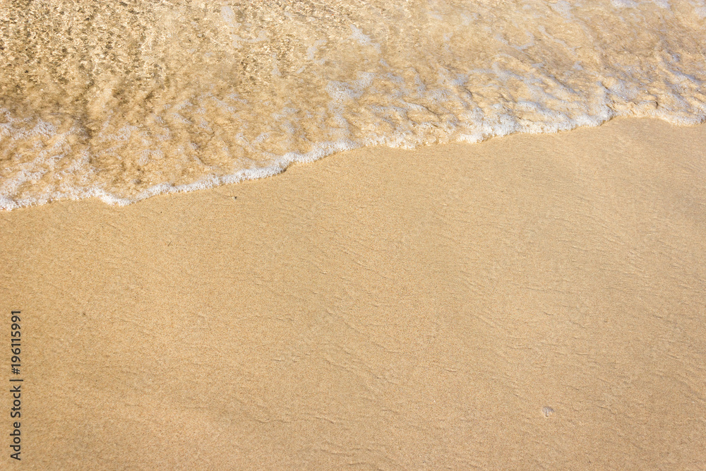 Soft waves with foam of ocean on the sandy beach background Soft waves with foam of ocean on the sandy beach background