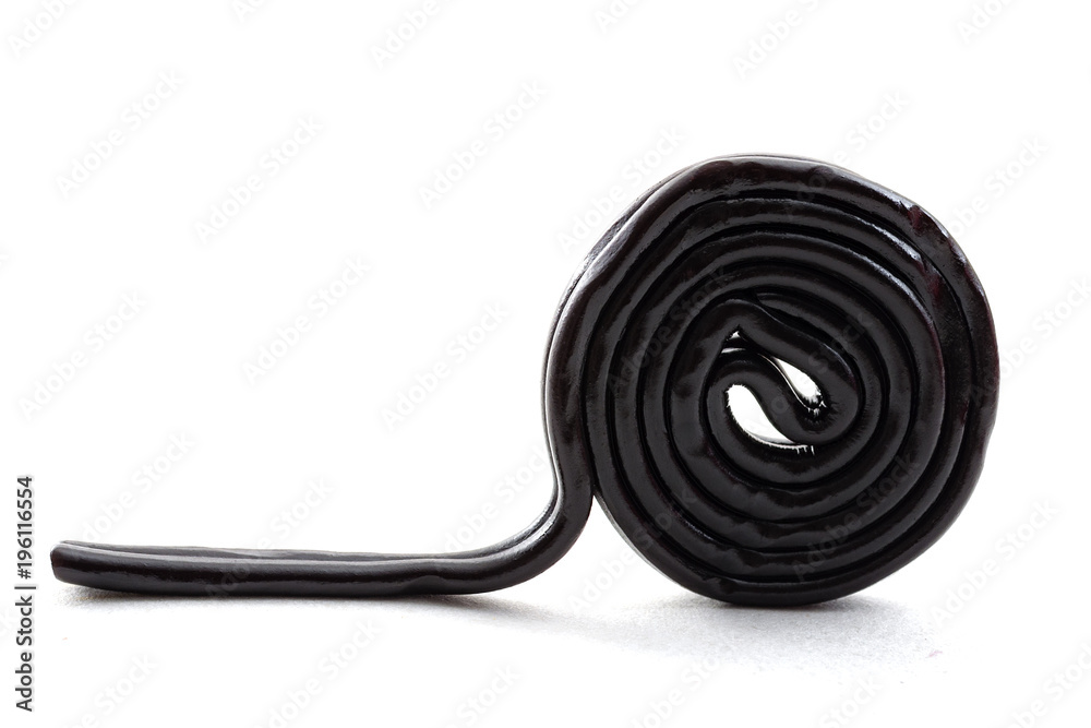 Sugar confectionery sweets and sweet candy concept with one black licorice or liquorice wheel or spiral isolated on white background