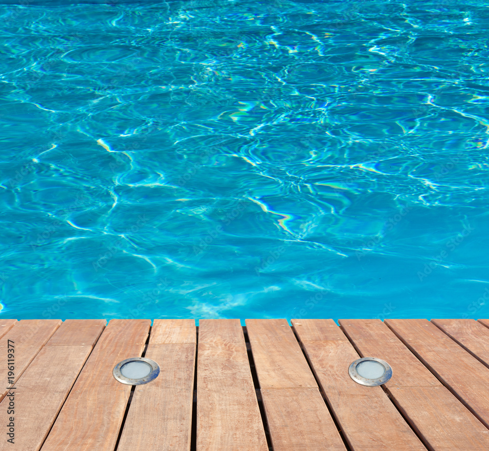 piscine bleue avec éclairage intégré dans plage bois 