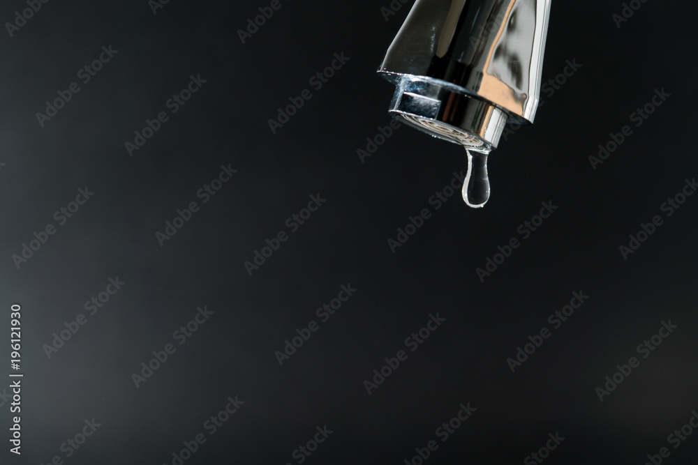 water drop on faucet with  black backgrounds, world water day concept