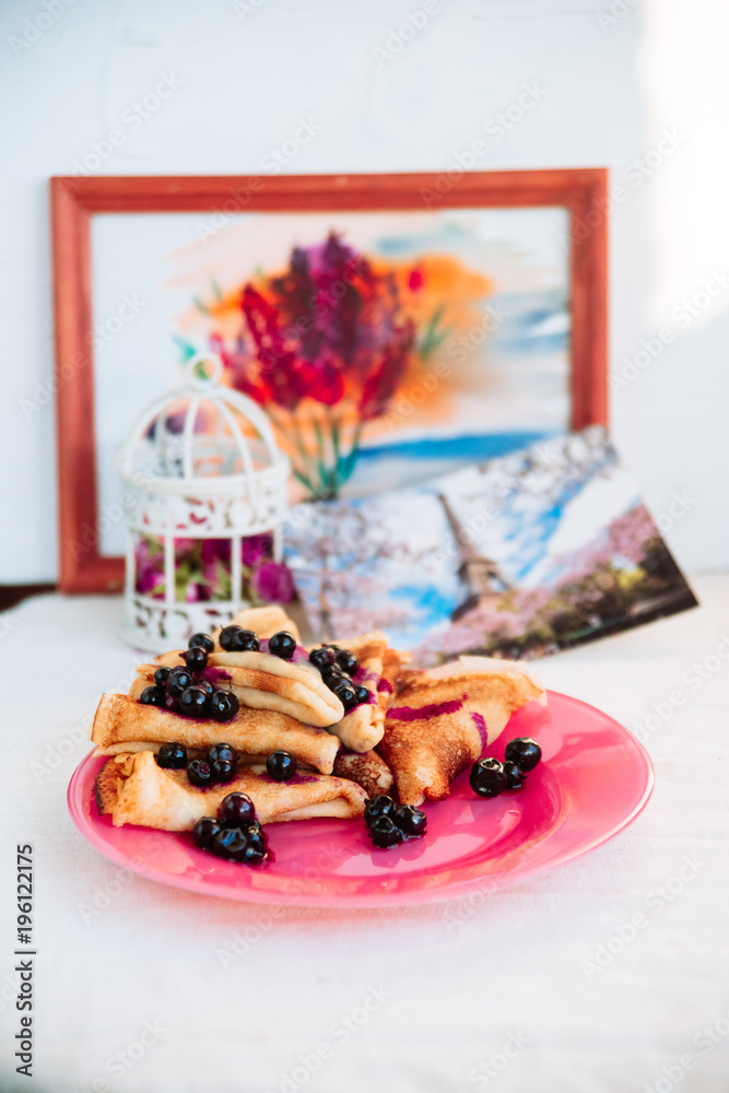 Breakfast: pancakes with blueberry berries, currants on a pink plate in the style of Provence.. dessert