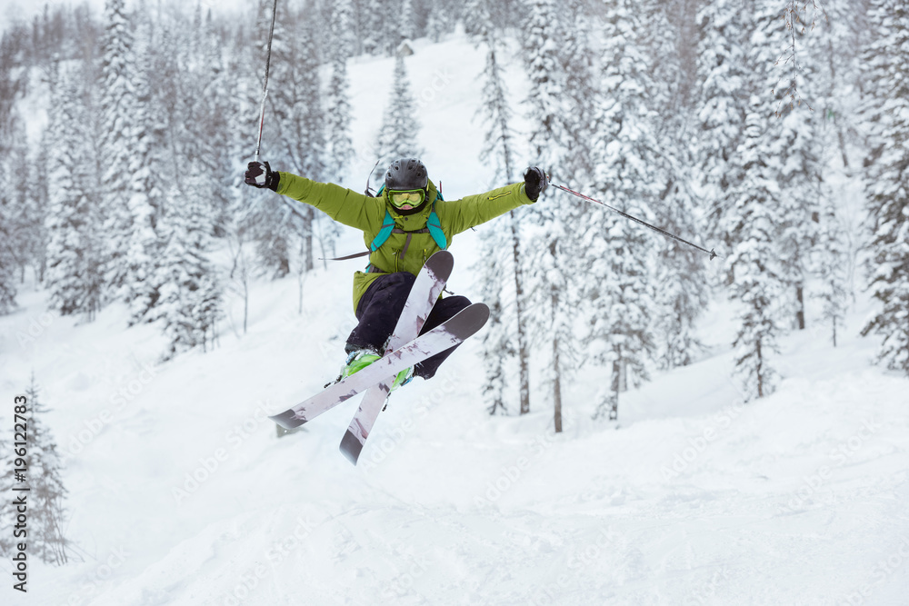 Skier jumps offpiste ski slope resort
