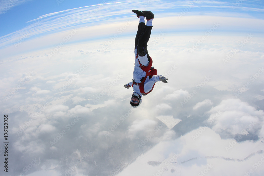 Skydiver is flying in the winter sky.