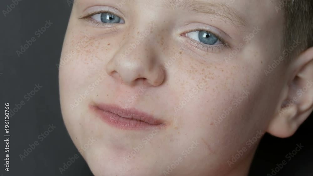 Blue-eyed, freckled teenager boy eat potato chips close-up view Blue-eyed, freckled teenager boy eat potato chips close-up view