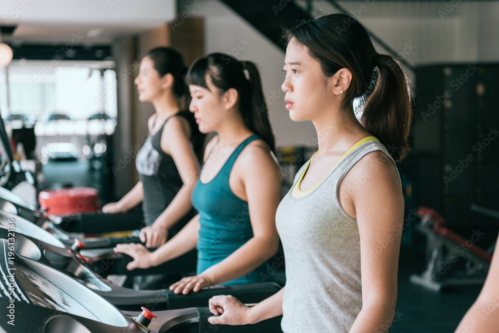 Group of young people running on treadmills