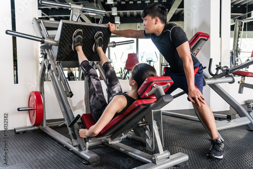 Woman using weights press machine for legs