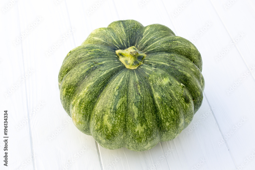 Green pumpkin on a white wooden background Green pumpkin on a white wooden background