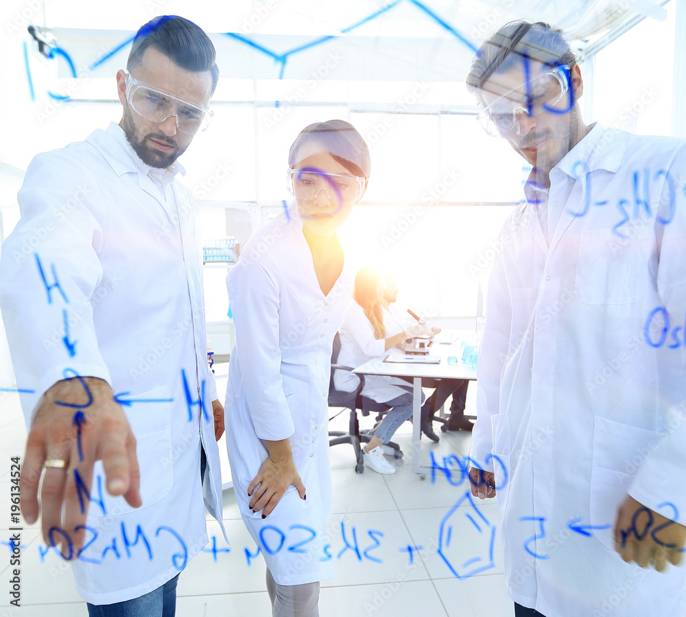 group of laboratory scientists discussing their research in the group of laboratory scientists discussing their research in the