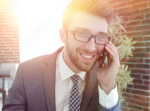 businessman talking on smart phone in modern office photo