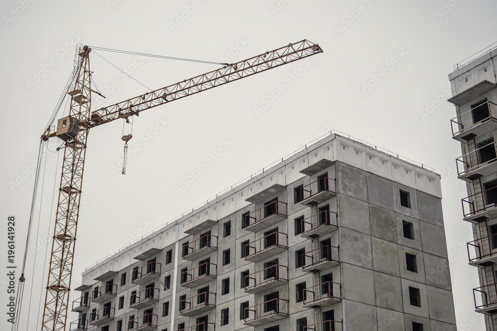 Incomplete construction of a cement building on a construction site with a crane Incomplete construction of a cement building on a construction site with a crane