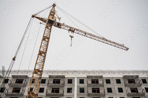 Incomplete construction of a cement building on a construction site with a crane