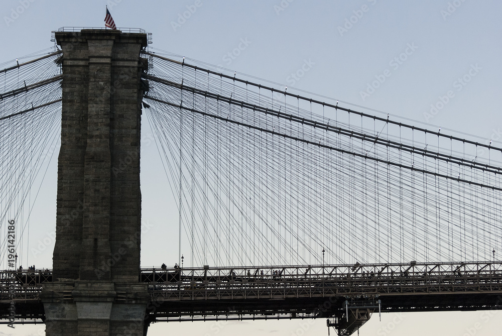 Fototapeta premium Brooklyn bridge detail/Pillar, deck and cables of the Brooklyn bridge in New York over Hudson river.