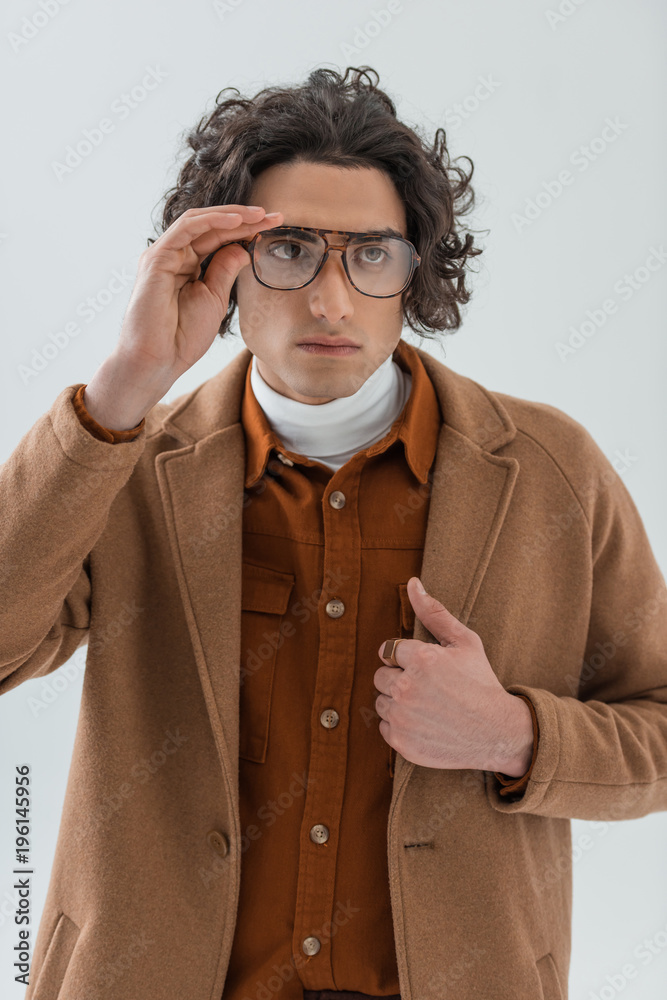 Young stylish man holding eyeglasses isolated on grey Young stylish man holding eyeglasses isolated on grey