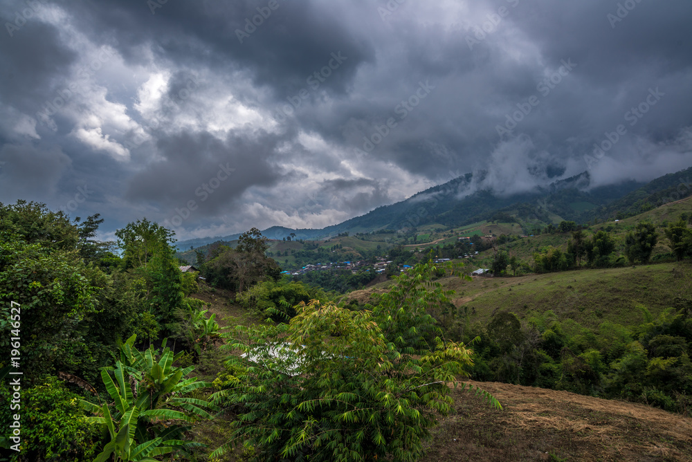 Village in the hill of forest mountain with cloudy sky behind, Traveling in Thailand