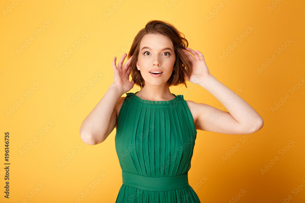 portrait of young attractive woman looking at camera isolated on orange portrait of young attractive woman looking at camera isolated on orange