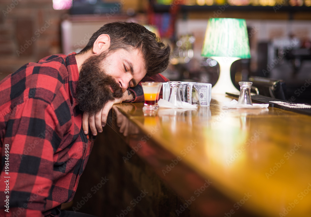 Man with tired face sit alone at bar counter Man with tired face sit alone at bar counter