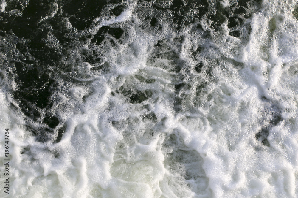 stormy creek. wave and foam in the flow. splashes, bubbles, waves, stream, ripples and crests of waves in a fast forest stream in winter