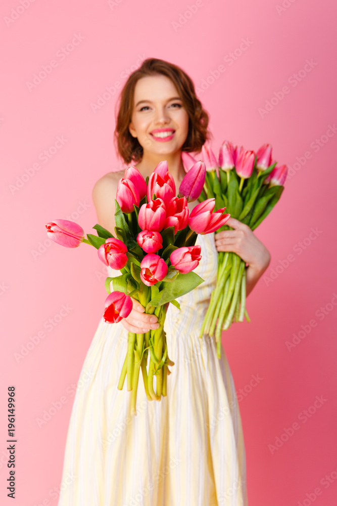 selective focus of woman with bouquets of spring tulips isolated on pink