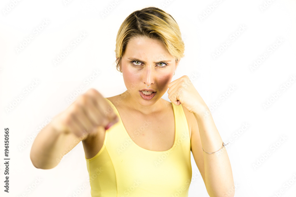 Angry young woman punching something against her. Blonde woman isolated on a white plain background