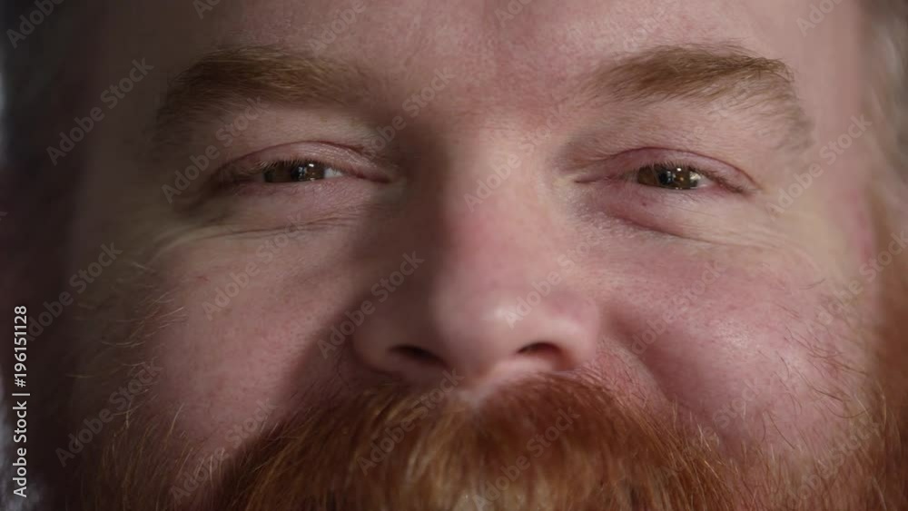 Tight shot of mans nose and eyes as his checks raise from him smiling. Tight shot of mans nose and eyes as his checks raise from him smiling.