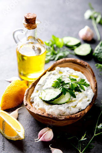 Tzatziki Traditional Greek sauce with ingredients cucumber, garlic, parsley, lemon, mint. Food Background.Snack, Meze in the dishes of the Olive Tree.Copy space for Text.selective focus.