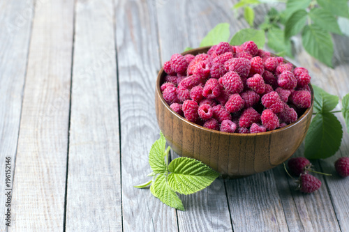 Sweet raspberries in bowl on wooden table. Close up, high resolution product photo