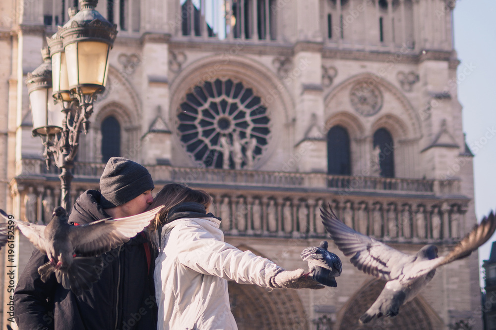 Tourists feeding pigeons in the square in front of the cathedral of Notre Dame Tourists feeding pigeons in the square in front of the cathedral of Notre Dame