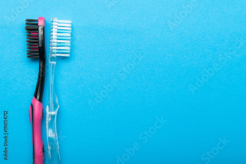 Two toothbrush on a blue background  empty space for text.