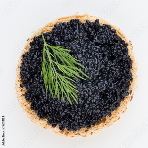 Canapes with black sturgeon caviar and spice isolated on the white background.