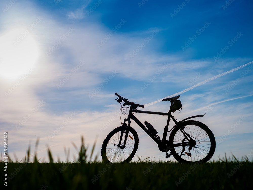 Bicycle silhouettes on the dark background of sunsets Bicycle silhouettes on the dark background of sunsets