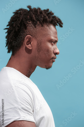 The young emotional angry afro man on blue studio background