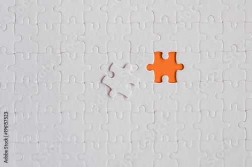 White details of jigsaw puzzle on orange background