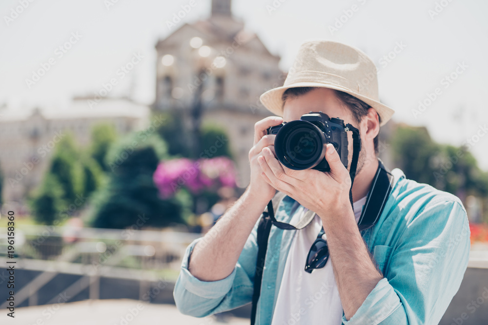 Portrait of handsome focused interested delightful creative professional successful stylish fashionable trendy fashion photographer wearing casual outfit taking photo of european old city