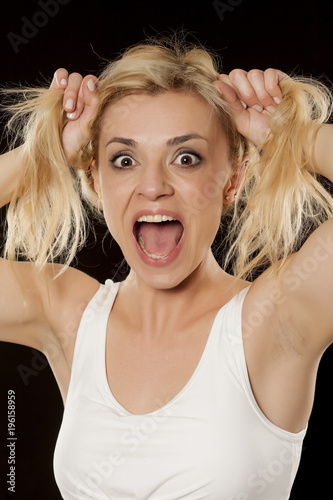 funny happy blonde posing on a black background