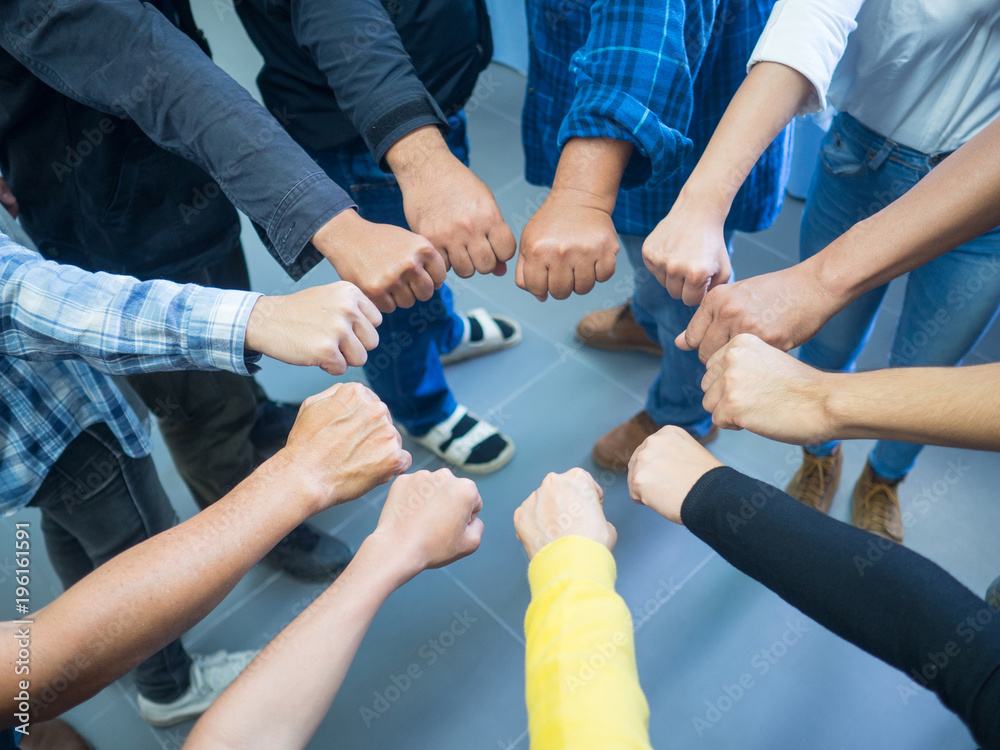 Closeup image of many people putting their fists together as symbol of unity. Teamwork Concept. Closeup image of many people putting their fists together as symbol of unity. Teamwork Concept.