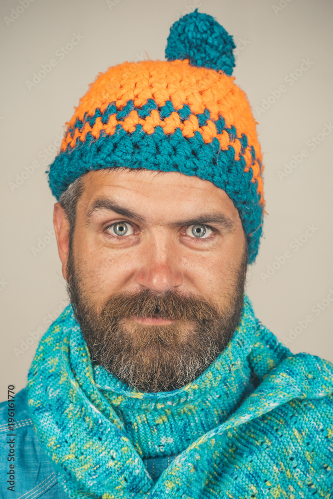 Men autumn/winter fashion. Handsome bearded man wearing autumn or winter clothing. Attractive man with beard and mustache wearing fashionable knitted scarf and hat. Man with scarf and hat. Closeup. Men autumn/winter fashion. Handsome bearded man wearing autumn or winter clothing. Attractive man with beard and mustache wearing fashionable knitted scarf and hat. Man with scarf and hat. Closeup.