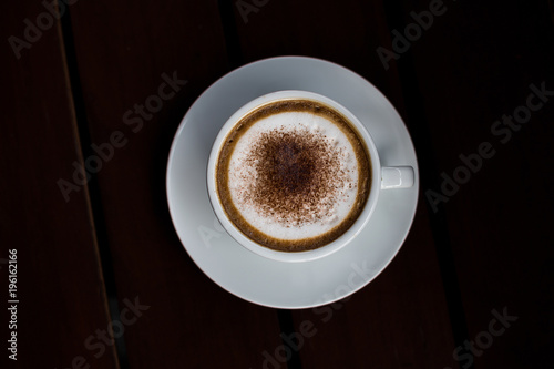 Coffee in a white cup on a wooden table.