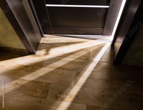 Rays of light from the door in a dark room