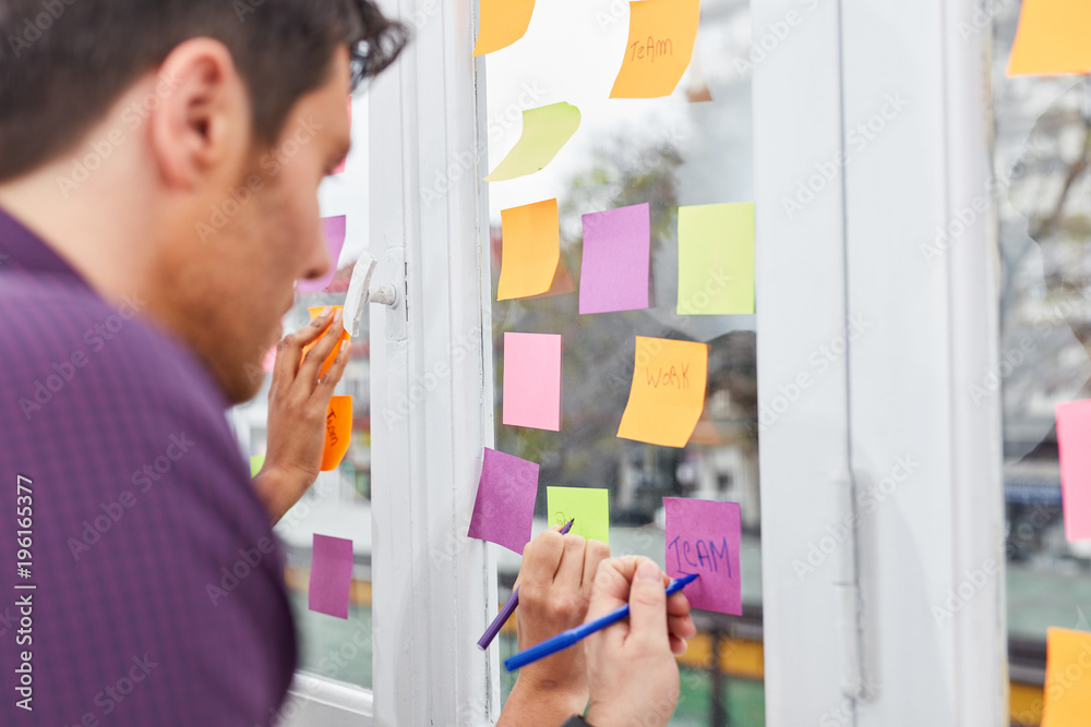 Fototapeta premium Kreatives Start-Up Team notiert Ideen auf Zetteln