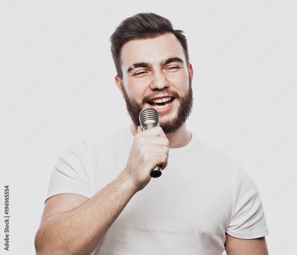 The entertainer. Young talking man holding microphone, Isolated on white background. The entertainer. Young talking man holding microphone, Isolated on white background.