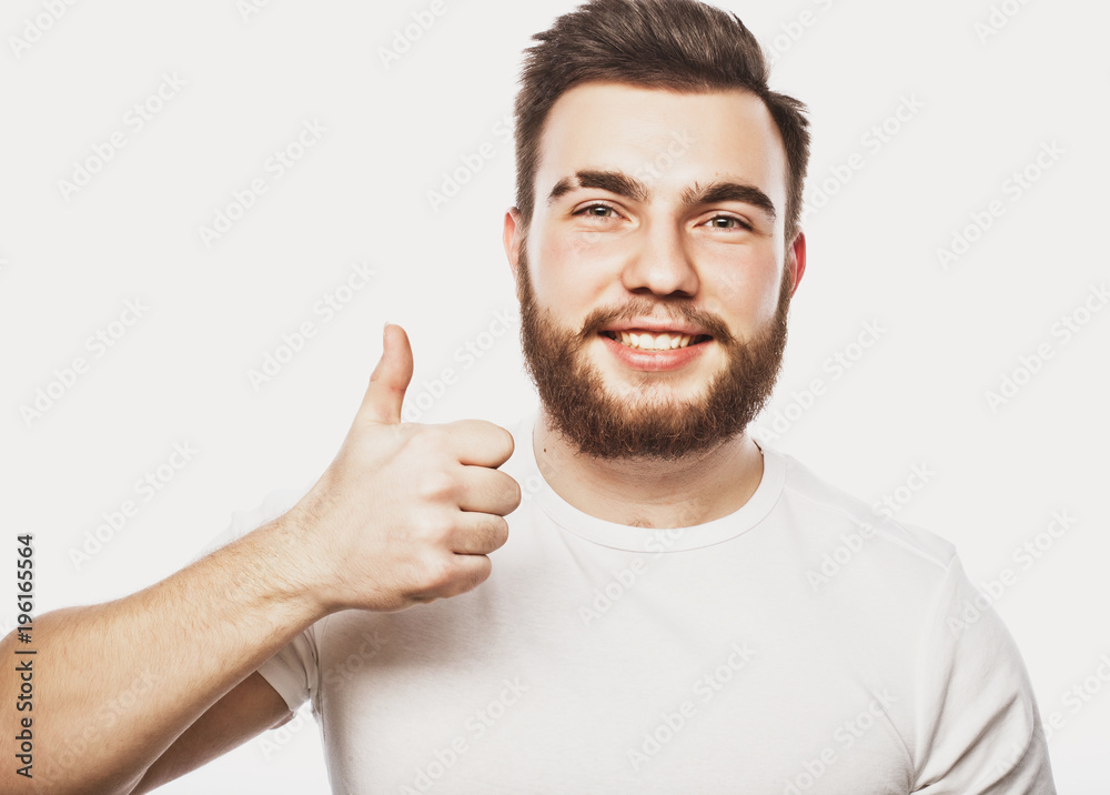 Portrait of a cheerful young bearded man showing okay gesture isolated on the white background Portrait of a cheerful young bearded man showing okay gesture isolated on the white background