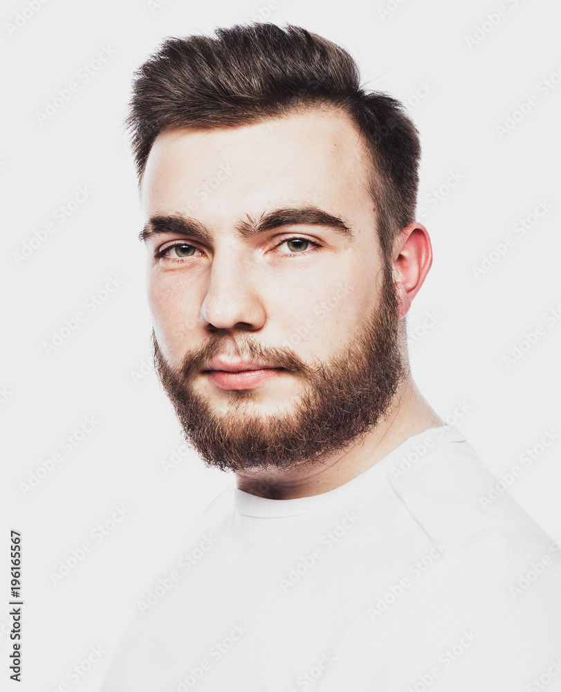 Fototapeta premium Portrait of a young bearded man in a white T-shirt